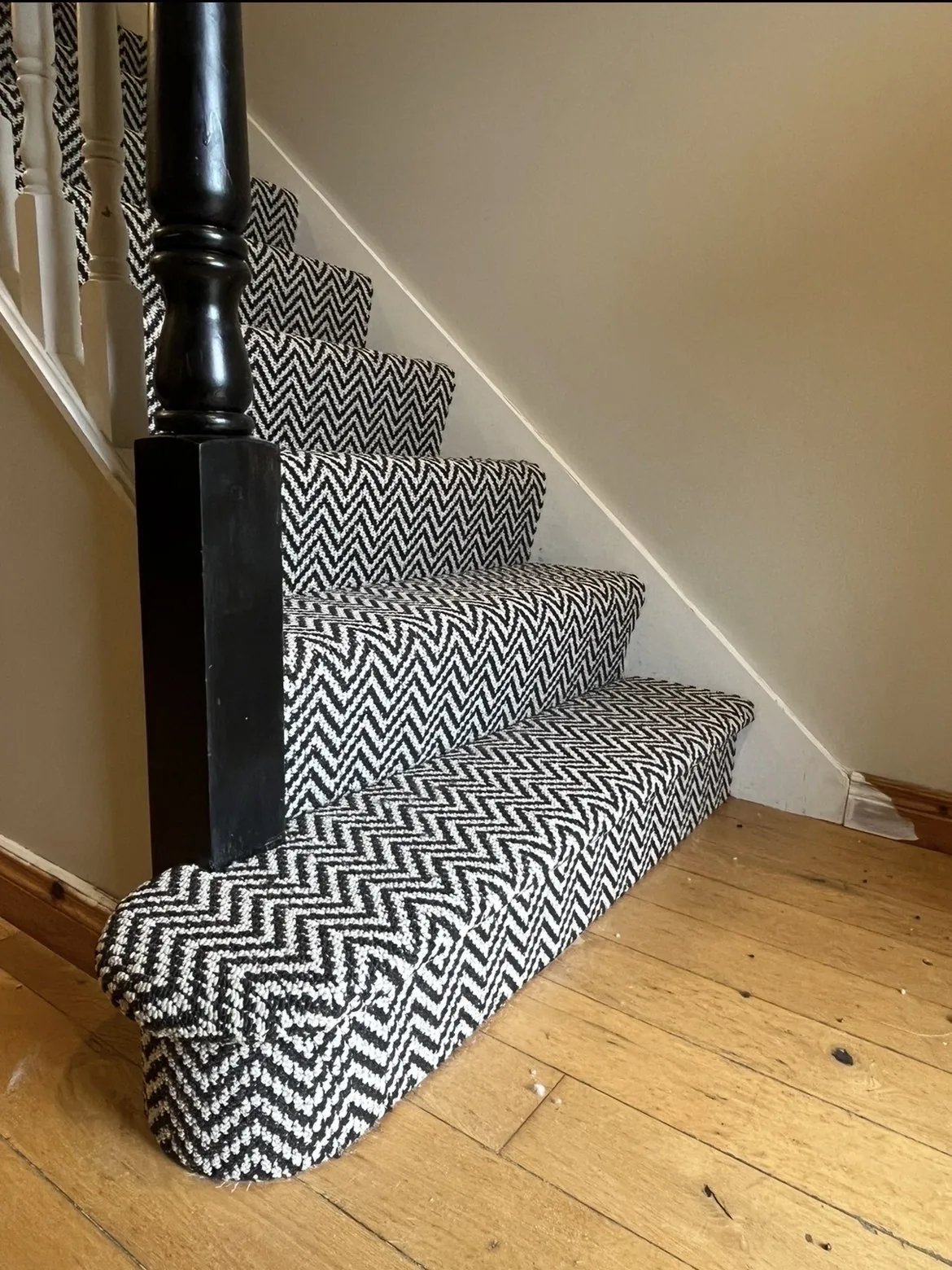 Geometric patterned stair carpet beside a wooden floor