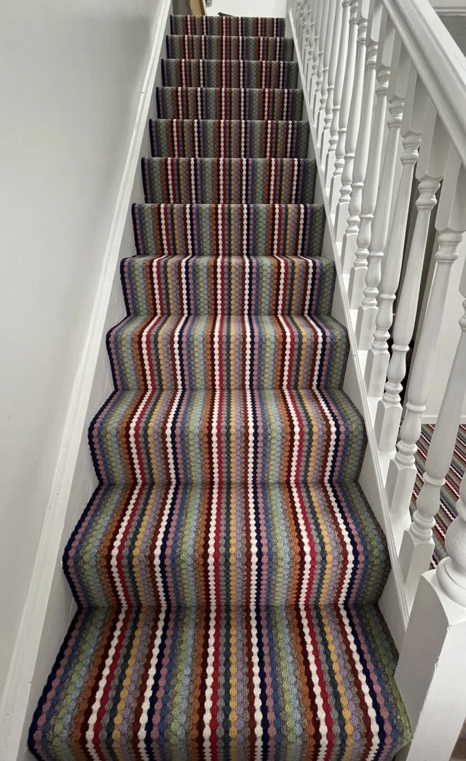 Multicoloured striped carpet fitted to stairs