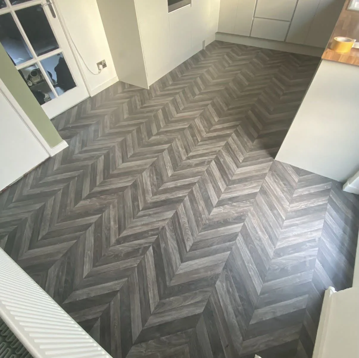 Grey herringbone-effect vinyl fitted around a doorway