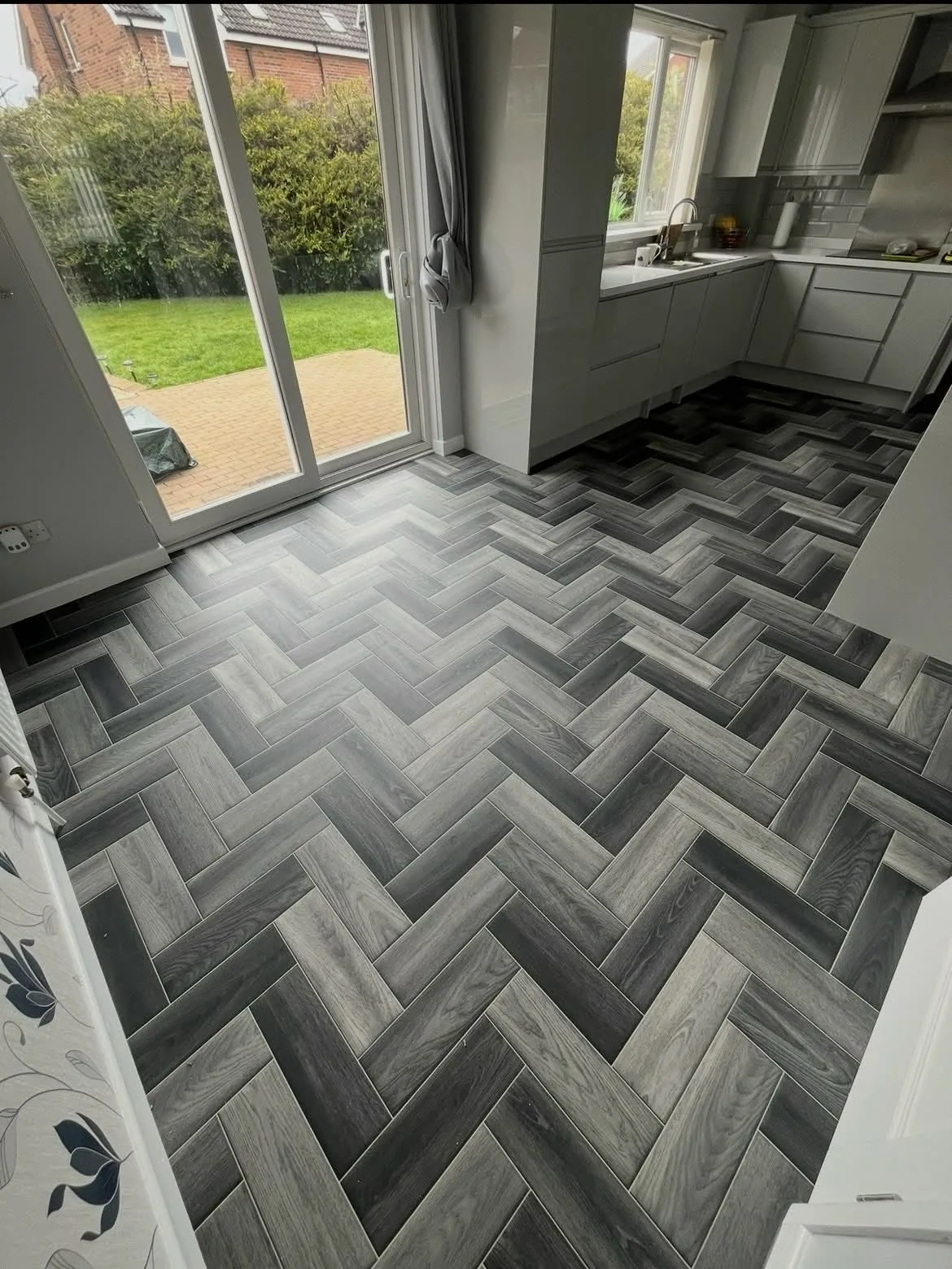 Grey herringbone-effect vinyl beside patio doors